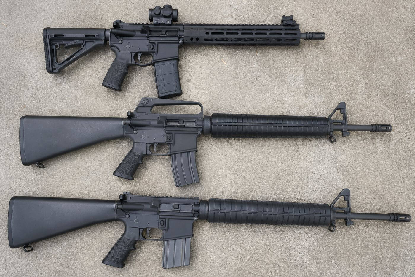 Trois AR-15 en configurations différentes, illustrant le débat M16 vs M4 sur la longueur de canon et la crosse