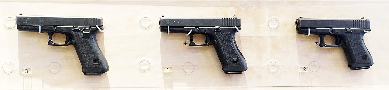 Trois pistolets Glock alignés, longueurs de culasse différentes