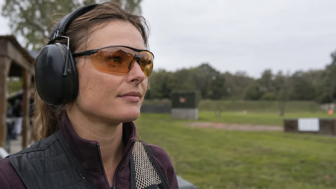 Lunettes de ball-trap à verre orange posées sur une table de stand de tir